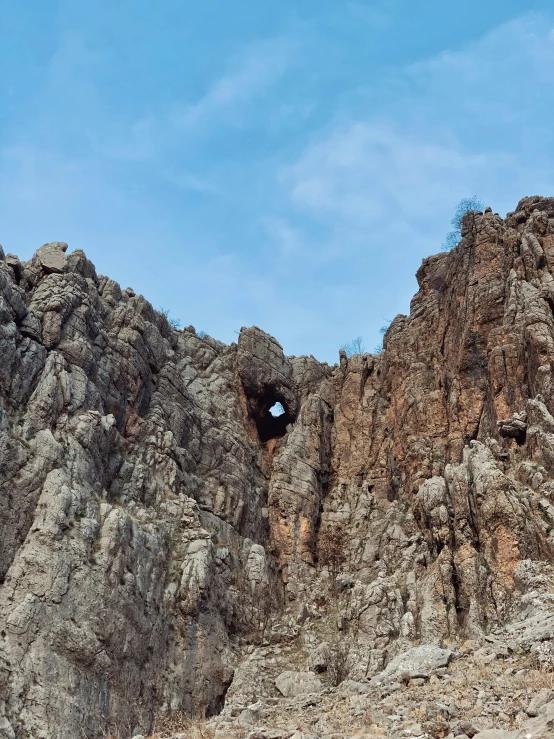 a cave between rocks under a blue sky