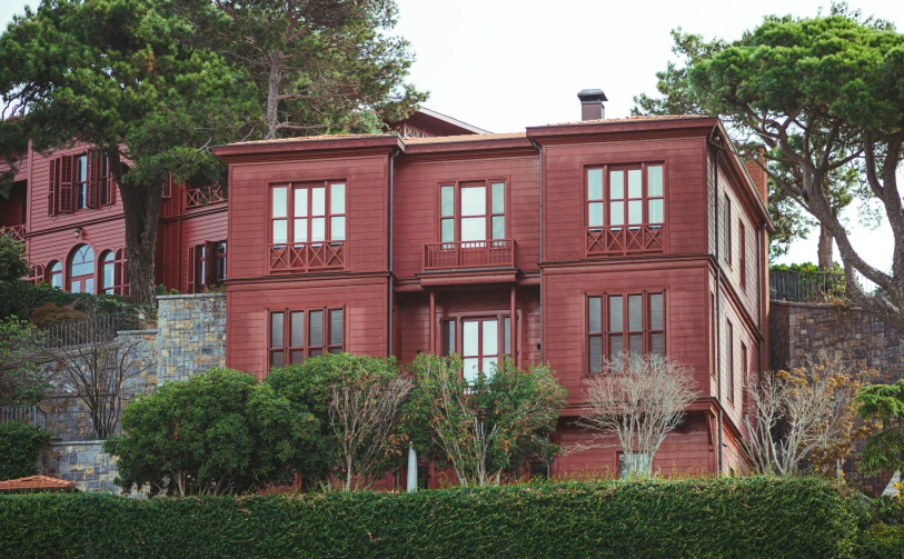 an old red building with several balconies on the top floor