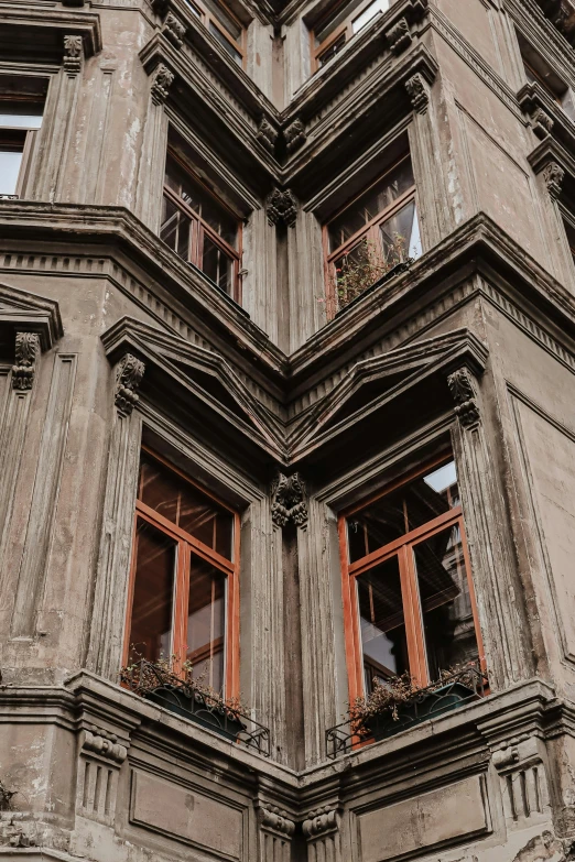 several windows are open on the side of an old building