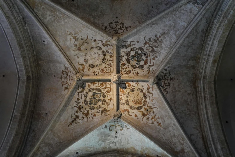 a decorative piece of art is covering the ceiling in an old church