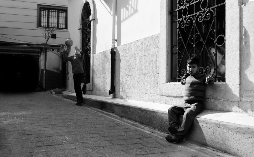 the boy is sitting on the step talking on the phone