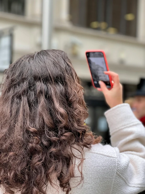 a woman holding up her cellphone and taking a picture