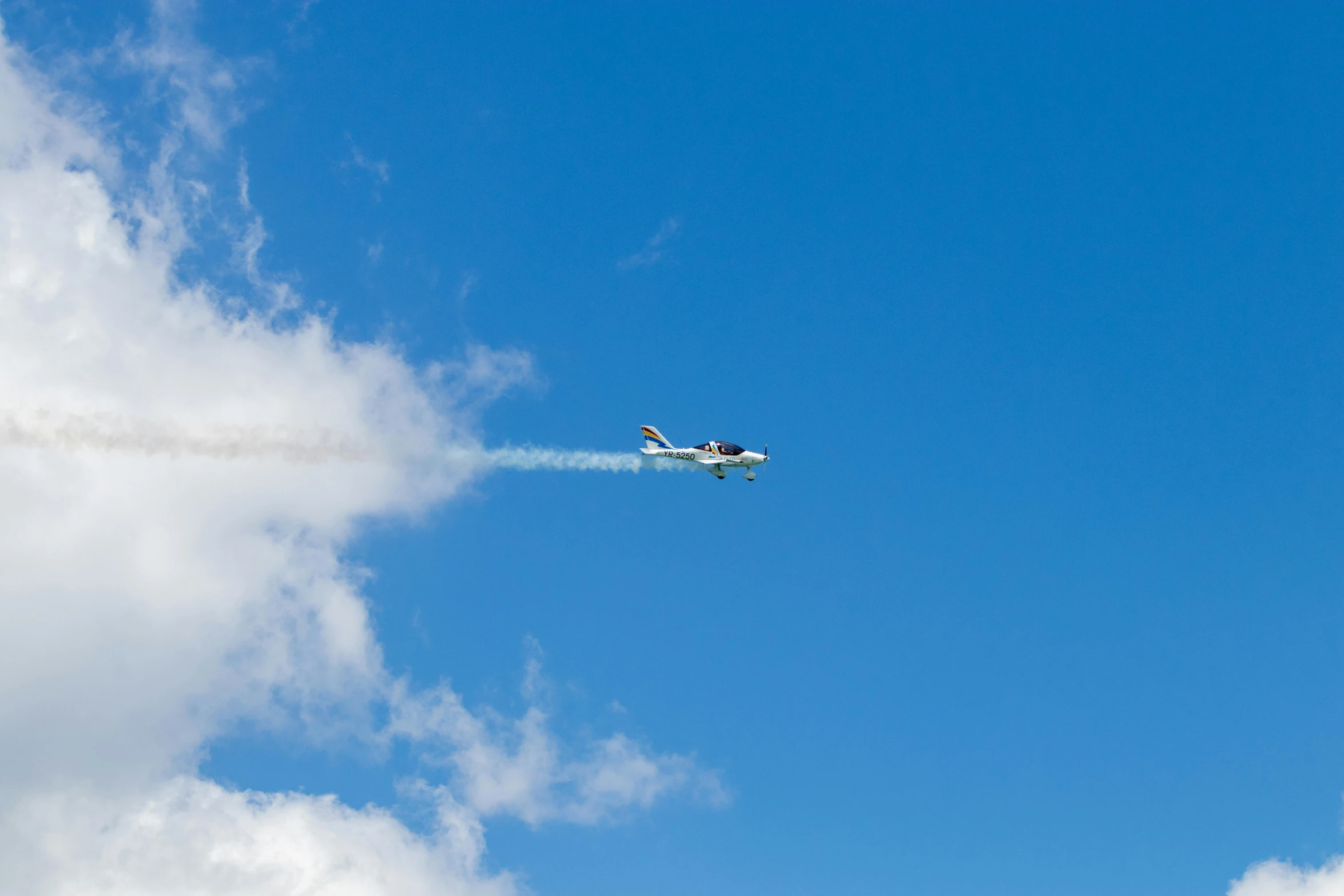 an air plane flying in the air with smoke trailing through the sky