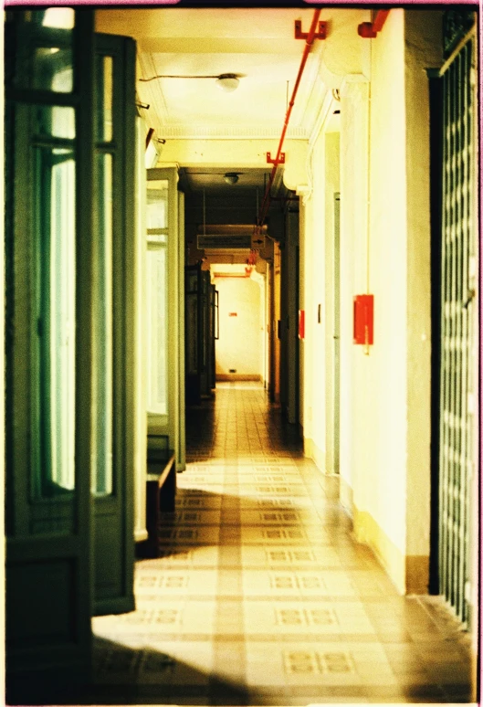 an empty hallway of a building with open doors and wooden floors