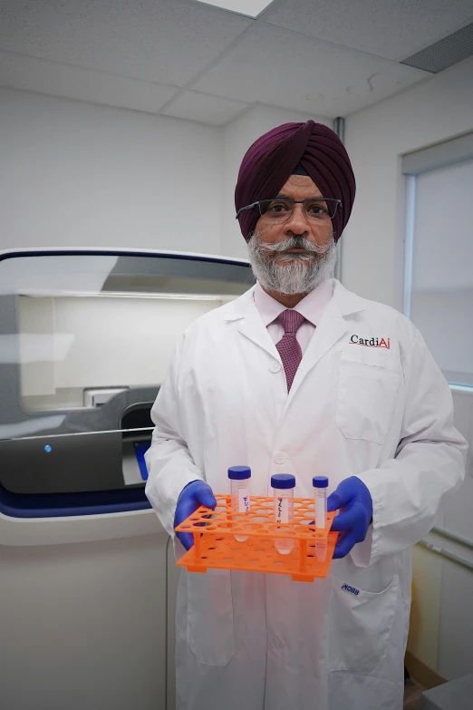 a man in white coat holding orange pipe test tubes