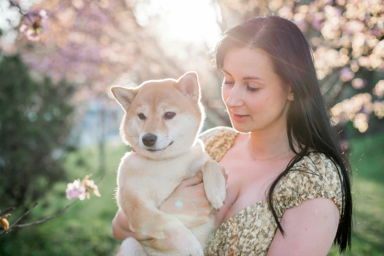 a woman in an antique dress is holding a puppy