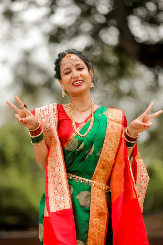 a woman in indian dress and holding her hand up