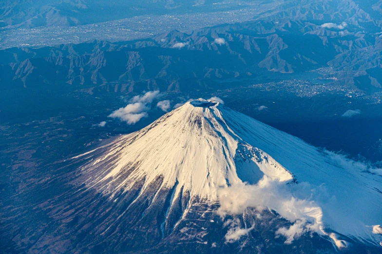 a snow covered mountain rising from below a blue sky