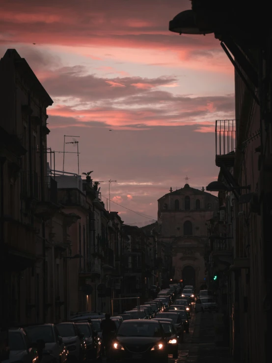 cars are parked along a street as the sun goes down