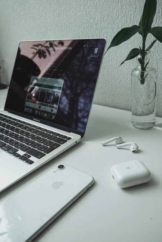 an apple computer sits on a desk with a cell phone