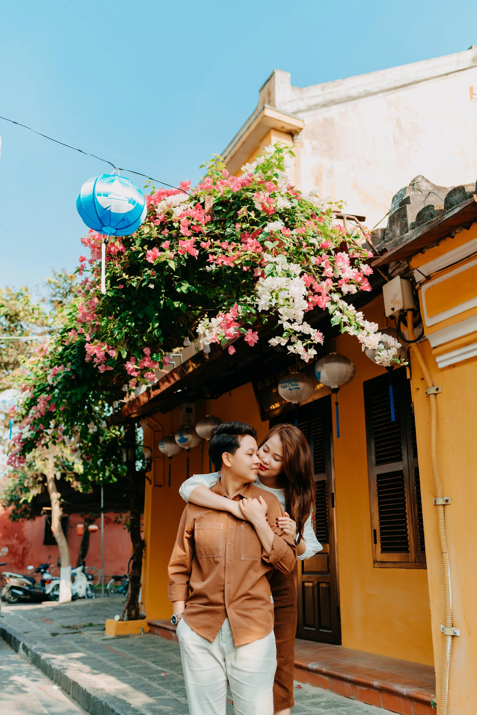 two people standing on the street with one holding another