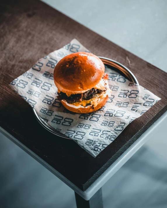 a burger on paper sits on top of the table