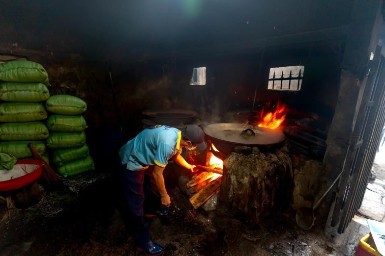 a woman preparing food in the kitchen with fire