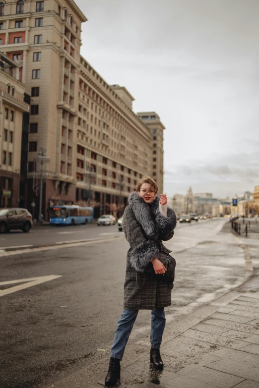 a woman is standing on the sidewalk and talking on her cell phone