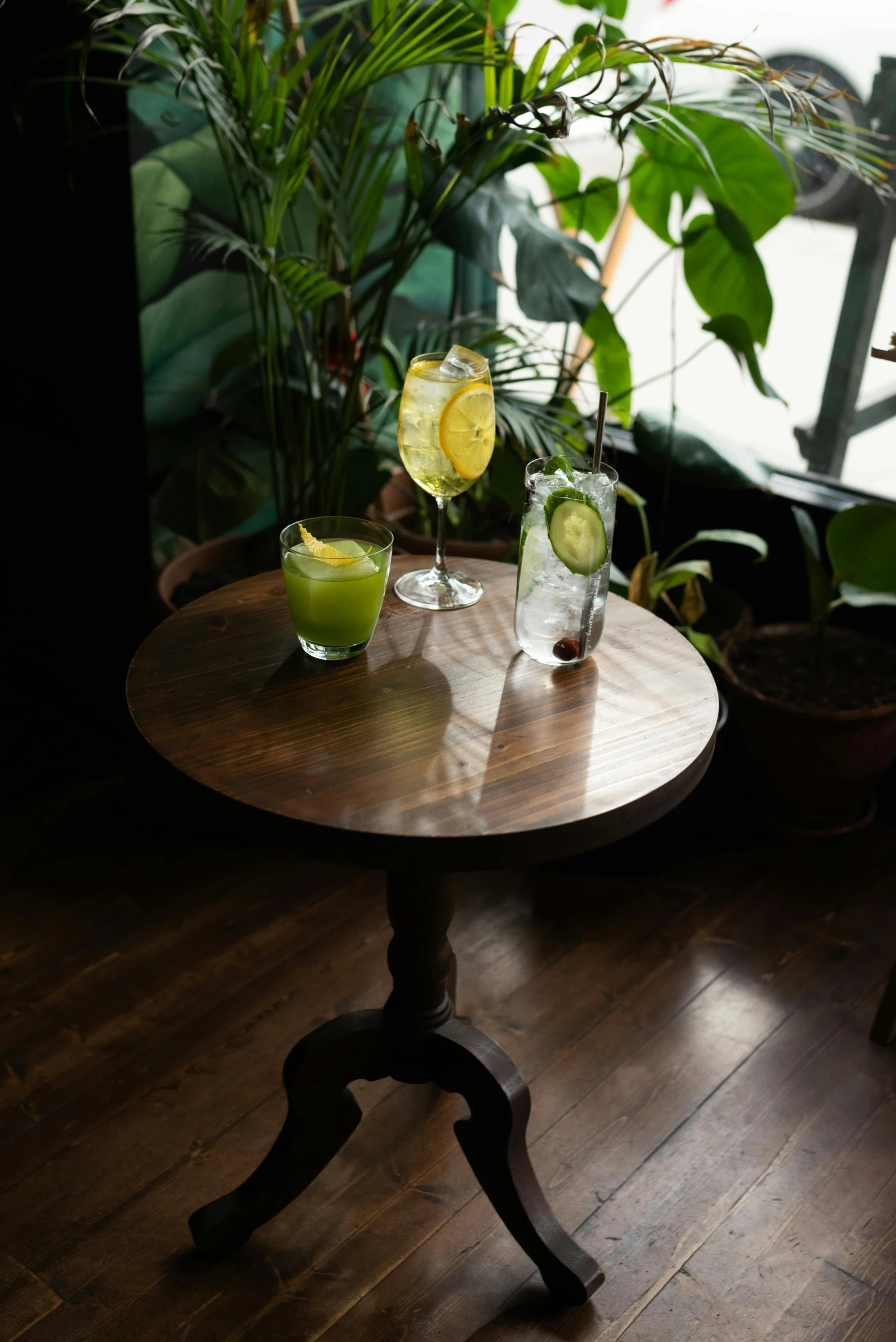 two glasses filled with liquid sit on a small table