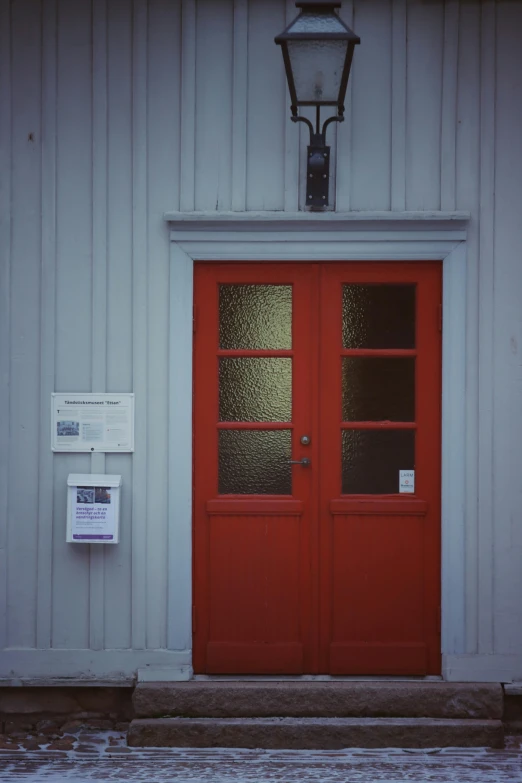 the two red doors are closed outside of the building