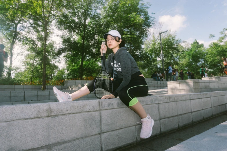 man sitting on a concrete wall looking down and talking on a cell phone