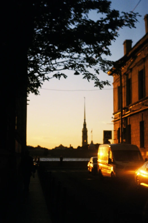 cars parked along a street with a clock tower in the background