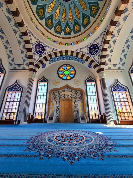 the inside of a large room with blue carpeting and large windows