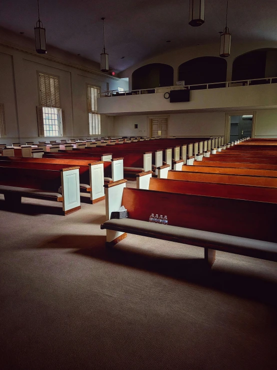 empty rows of benches sitting in a large building