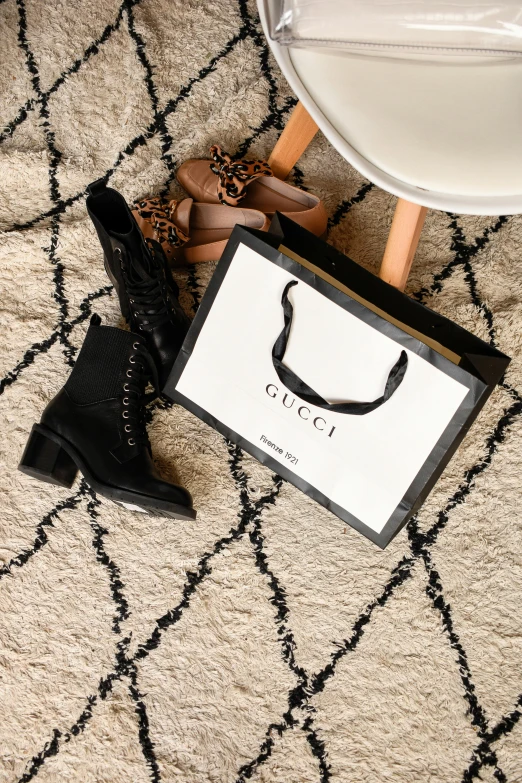 an empty box sits on a carpet near heels and a pair of shoes