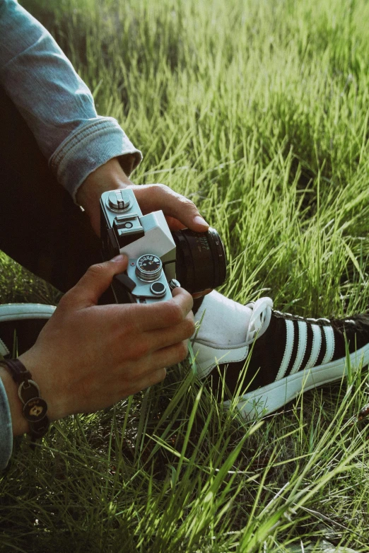 someone that is tying his shoes in the grass