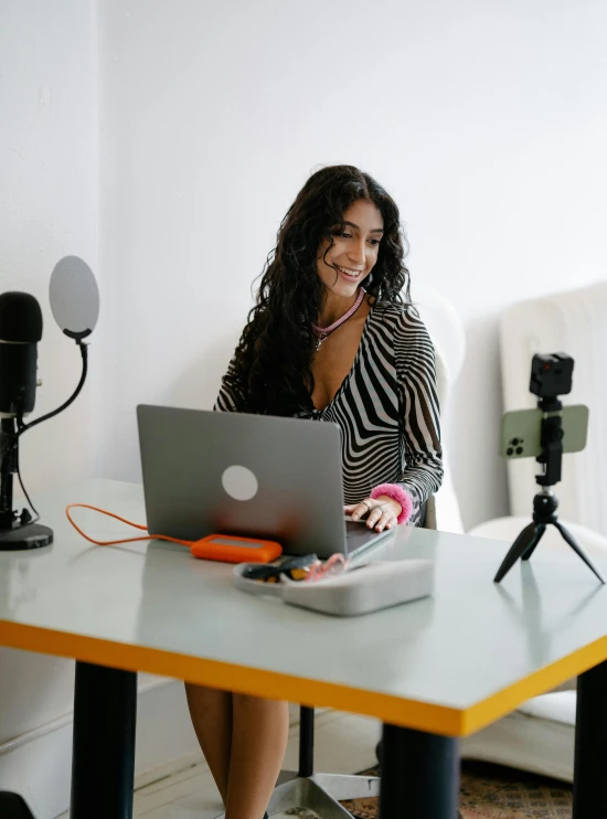 a woman is sitting in front of her laptop on the desk