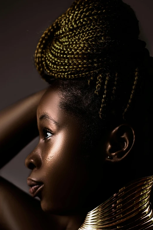 an african woman wearing a gold necklace and a big id