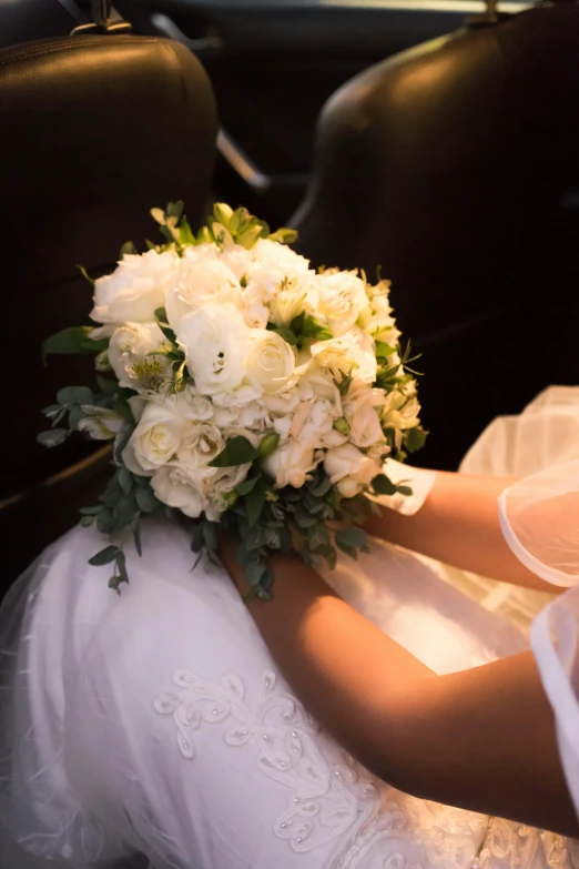 bouquet of white flowers on the back of a bride's back