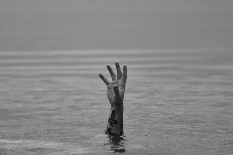 someone that is reaching into the water with their hand