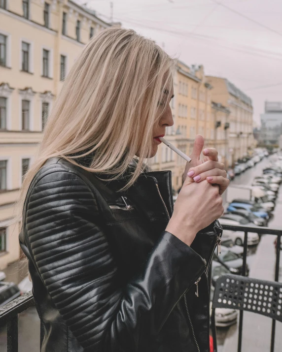 a woman smoking while leaning on a railing