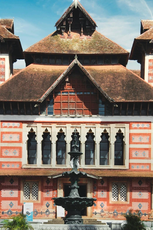 a building with a fountain in front of it and two large towers above