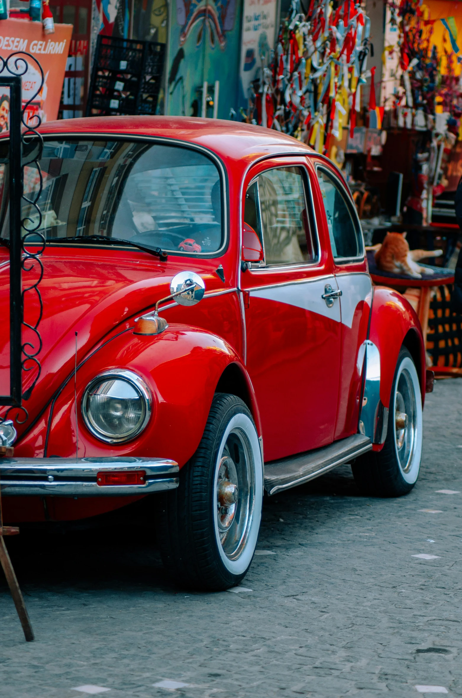 a red and black vintage car is parked on the street