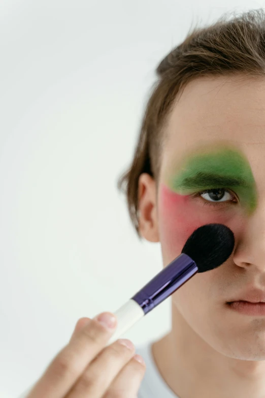 a woman looking into the camera with makeup brushes in her hand