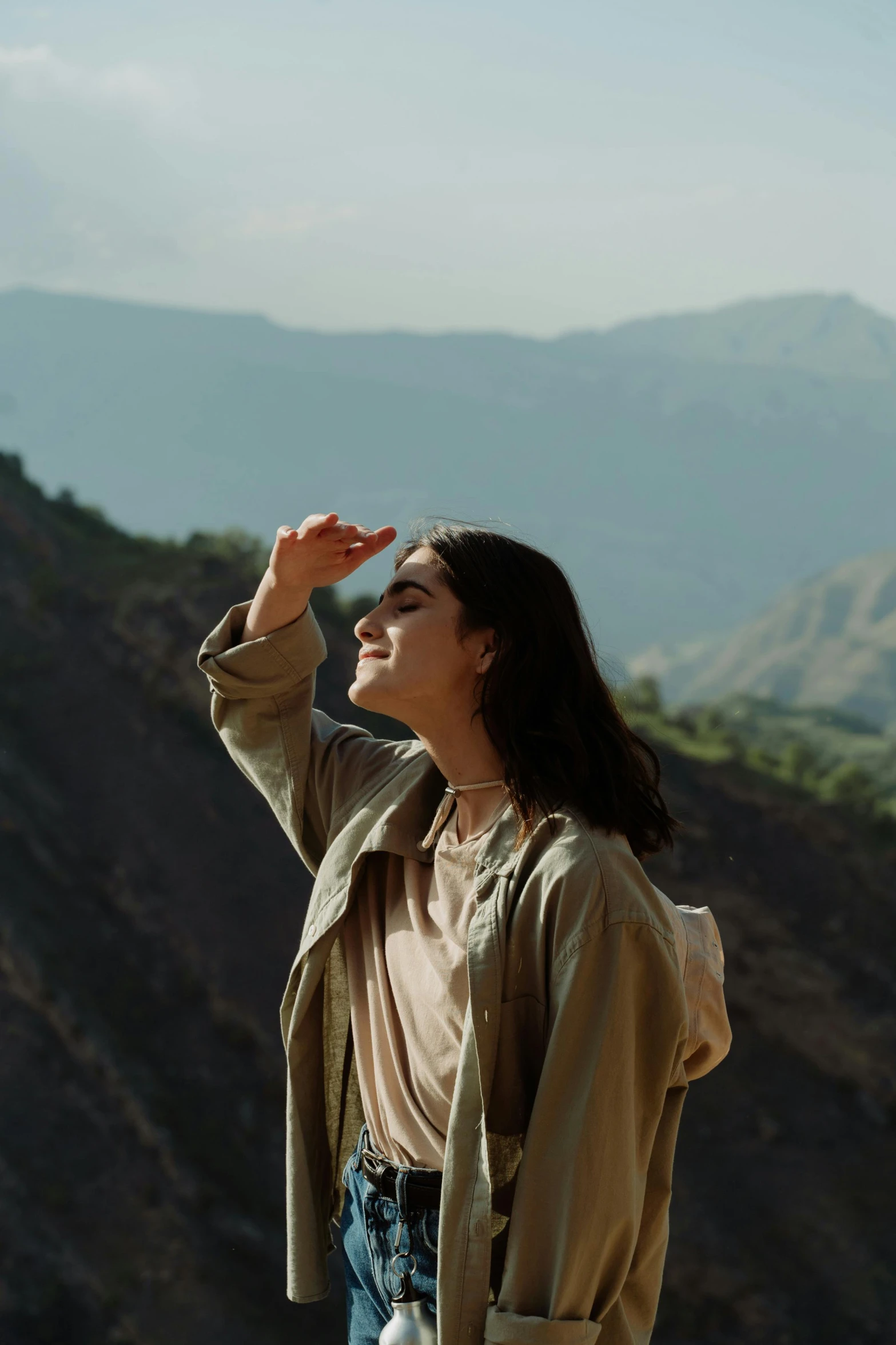 a young woman who is standing on a hillside