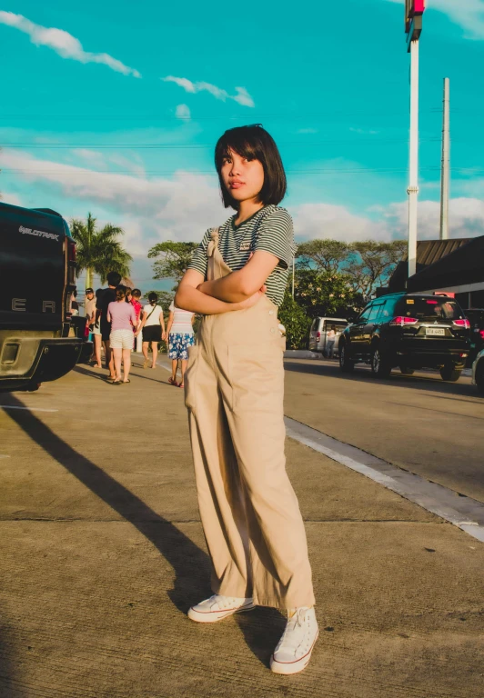 a young lady with her arms crossed is standing on the pavement