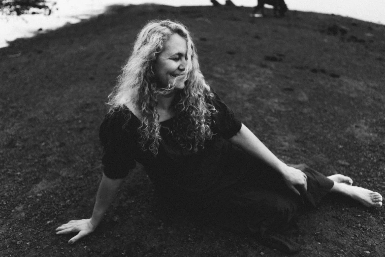 a woman is sitting on the ground posing for a po