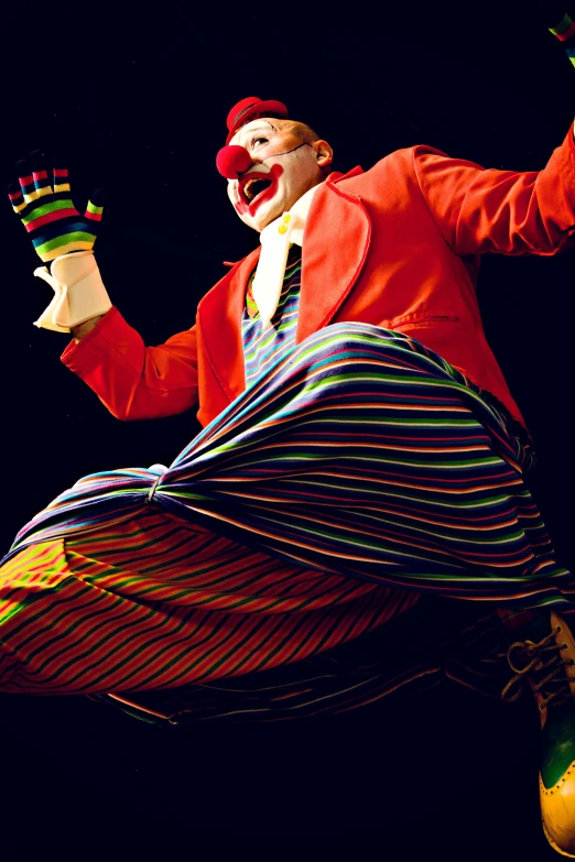the person is dressed in a striped clown outfit