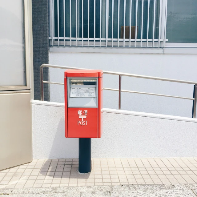 a red and black box is sitting on the sidewalk