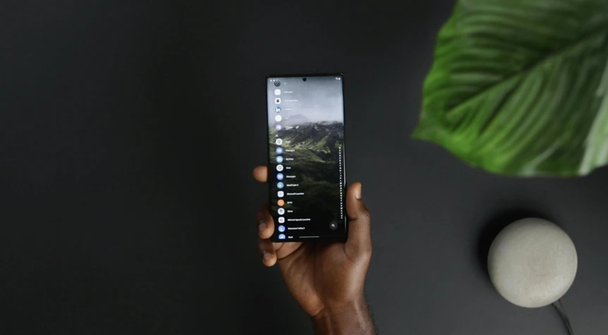 a person holds up a smartphone on a table