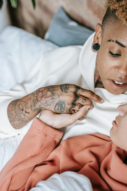 a woman laying on a bed with two tattoos on her body