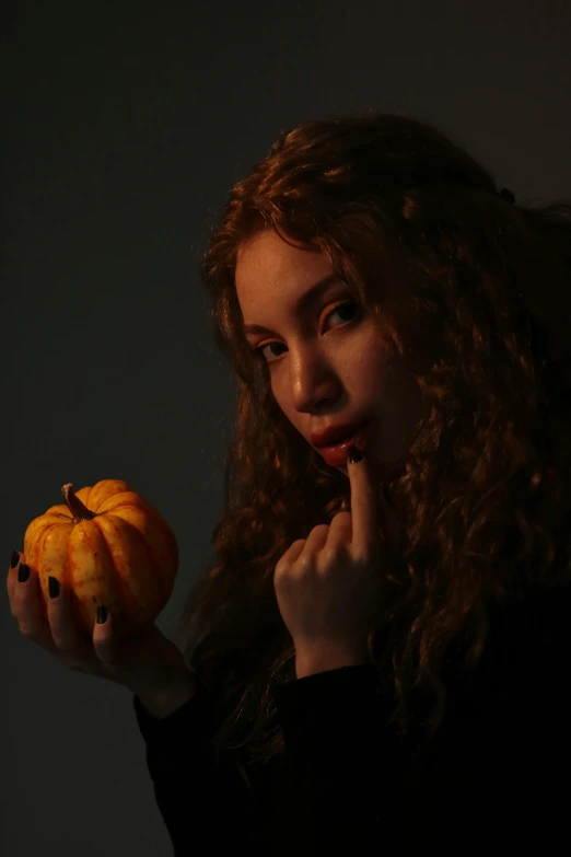 a girl is looking at a pumpkin and is thinking