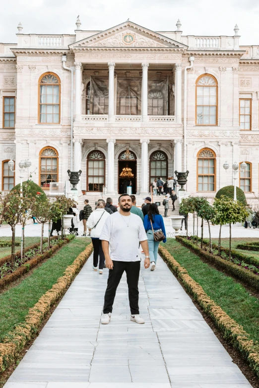 man with a beard standing in front of a large building