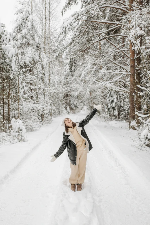 a woman is on the snow and has her hands raised