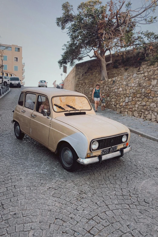 an old car is sitting on the gravel on the road