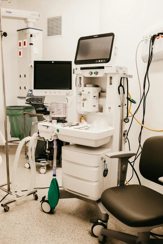 an hospital room with multiple monitors, equipment and medical supplies