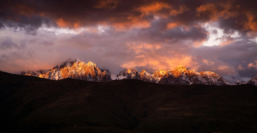 a number of mountains under a cloudy sky