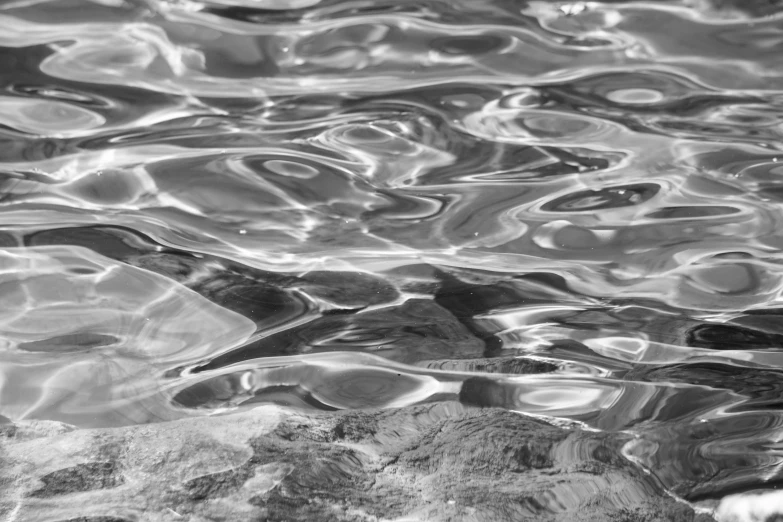 water reflecting the patterns on top of a rock