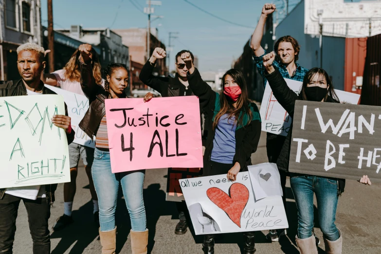 there are many people standing in the street holding signs