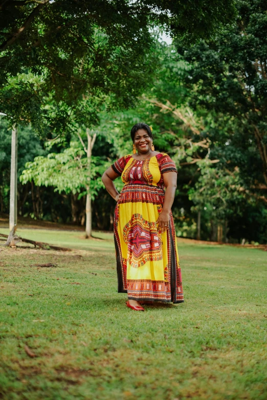 the woman is standing on the grass in her dress